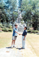 Pham Thanh Cong, survivor of the My Lai Massacre, greets Stephen Harrison in front of the main statue of the memorial site.
