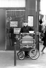 A French organ grinder plays in the Latin Quarter of Paris. Street performers can be found all over the city entertaining for donations.
