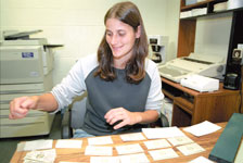 Barb Gambosi laminates telephone lists for the athletic department.
