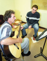 Guitar instructor Joesph Leiter shows Derek Bishop, senior performance arts major, the correct rhythm for the classical piece of music he is learning.
