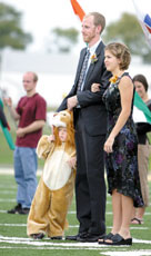 Jaime Green and Butch Loveall, secondary education majors, stand with ButchÂ´s son Josiah, before the royalty crowning at the Homecoming football game, Oct. 11.
