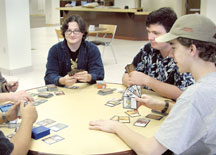 Honing up on their strategies, Matt Porte, left, Sam Jones and Nathan Hurley play a round of Magic
