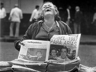 A Costa Rican newspaper vendor is overjoyed that Dr. Oscar Arias, a Latin American leader, received the Nobel Peace Prize in 1987.
