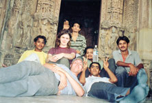 Mac Kenney, junior French and sociology major, bottom left, Alice Ensor, junior communication and German major, second from left, sit with a group of young men in an abandoned temple.
