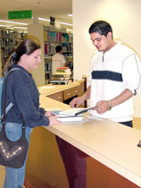 Among other duties, Prabhat Mishra helps students, such as Sherry Sands, junior elementary education major, find and check out books in Spiva Library. Mishra is from Katmandu, Nepal. He said he reminds people Nepal is the home of Mt. Everest.
