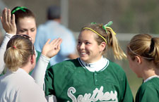 Shari Gates, freshman third baseman, is congratulated by her teammates after a successful inning during the April 1 game against Northeastern State University. The Lions split the games against NSU, 4-3 and 1-2.
