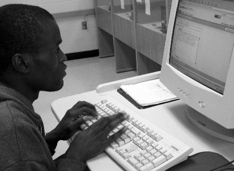 Steven Odhiambo from Naiorbi, Kenya, sophomore computer aided drafting and design major, sits in the language lab working on the computer. He also works part time at the Southern bookstore.
