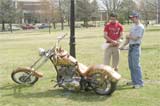 Caleb Cupp, junior education major, talks with Chris Carson (right) of Thompson Choppers about Bootlegger, a corn whiskey-fueled motorcycle on April 5.
