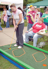 Elizabeth Sapp, senior teacher education major, (left) plays Cosmic Golf during the Fall Forward Aug. 24 as Denise Lee, manager of Cosmic Mini Golf, watches for a hole-in-one. The person who receives a hole-in-one wins a free game.
