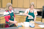 Debbie Cash, left, watches as Judi Stiles prepares potato chip cookies. The cookies are featured in the Southern Cooks cookbook which was the inspiration for the show.
