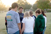 Austin Mayfield, sophomore business management major, center, leads a small-group prayer during See You at the Pole Sept. 21.
