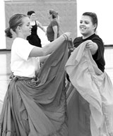 Vanessa Copeland, senior international studies major (left) and Leslie Parker, Spanish Instructor, take part in the Folklorico dance classs. they are wearing practice skirts, which weigh much less than the traditional Folklorico skirts.
