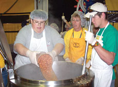 Derek Mitchell, freshman computer forensics major (left), and Brian Gunnels, sophomore general business major, stire baked beans and ham for approximately 4,000 people a day near New Orleans.
