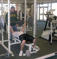 Chris Landstad, junior biology major, lifts weights spotted by Kevin Ferdig, senior biology major.
