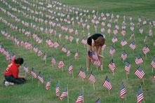 Jessica Smith, left, freshman undecided major, and Susan Messner, night-shift Department of Public Safety officer, place flags in front of Webster Hall Aug. 30 in remembrance of the soldiers who died in the Middle East. 3,000 flags symbolize Arlington National Cemetery.
