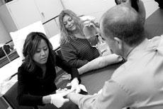 Chiho Sato, sophomore student of respiratory therapy (black shirt), checks Clinton Hudsons, director of clinical education, pulse while Kim Manning, sophomore student of respiratory therapy (blue stripe), assists with a medical competency test.
