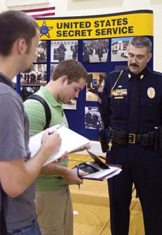 Jason Poynter, sophomore computer information science, computer network administration and criminal justice administration major, and Chris Landstad, junior biology major, talk with a representative from Joplin Police Department at the criminal justice department career fest Sept. 27.
