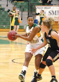 Southern guard India Wood passes around an Emporia State University defender. The women defeated Emporia State 72-49 and the men fell 73-72 in the Feb. 7 games.

