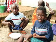 Issac and Ormond enjoy a meal in their new clothes at George Achibras house the day after their rescue from Lake Volta.
