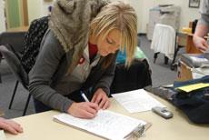 Caitlin Stayton, sophomore undecided major, signs a petition to place a drug reform initiative on the ballot in Joplin.
