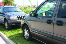 Julie Lybarger/The Chart Vehicles on the grass in Lot 39 sport warning tickets during the first week of classes. Despite student complaints, University officials say Southern has plenty of parking spaces.
