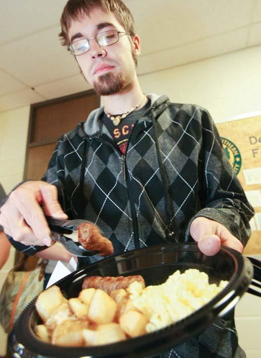 Zach Wheeler, sophomore creative writing major, fills his plate at Tuesday’s Bagel Breakfast.
