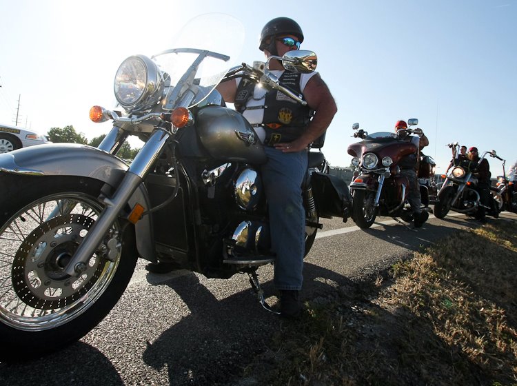 Members of the Covenant Motorcycle Ministry line the side of the Newman Road and rev their engines to drown out the voices of Westboro Baptist Church protesters.
