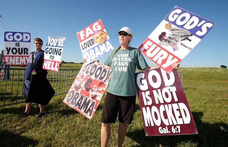 Rachel Hockenbarger (right) and her 15-year-old son Stephen of the Westboro Baptist Church, along with five others, protest President Obama and the city of Joplin Monday evening before the Joplin High School graduation.
