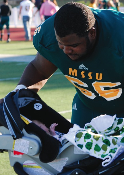 Senior Brandon  Williams looks in on his son, Ryder, after Saturday’s game against Northwest Missouri State University. Williams had one sack in the game, taking sole possession of the all-time Missouri Southern sack record, passing Lion legend Ken Shorten.
