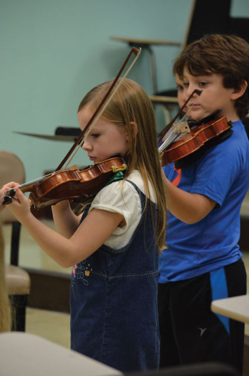 Ryleigh Williams and Coran Furguson practice playing the violin at Missouri Southern on Nov. 18.