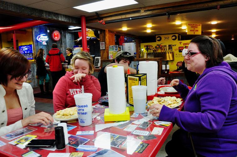 Juliana Tindell (left) and Rikki Appier (right) along with friends Logan King and Autymn Ganz, all Pittsburg natives, share a plate of nachos at Fuzzys Taco Shop on Feb. 26.
