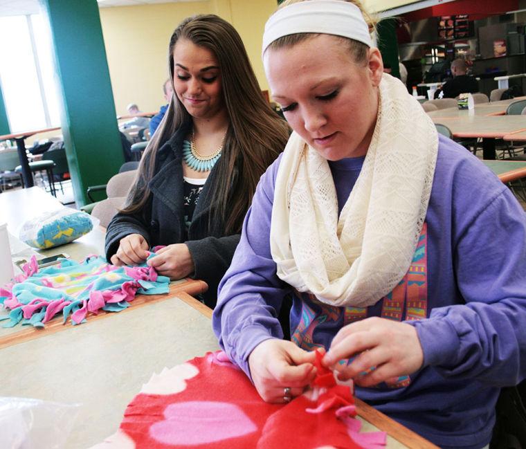 Junior nursing major Camden Blaes (Left) and sophomore sociology major and criminal justice minor Montana Vicory create “make n’ take” pillows during Wellness Wednesday in the Lion’s Den on March 5, 2014.