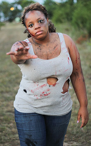 Doris Runnels, a junior psychology major keeps in character as she walks the zombie trail on Friday, Aug. 22 at the cross country track.