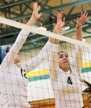 Junior Callie Whetstone and junior Abby Finder attempt a block against Cameron on Oct. 22, 2013. The Lions lost in three sets while Whetstone accumulated seven kills on the night.