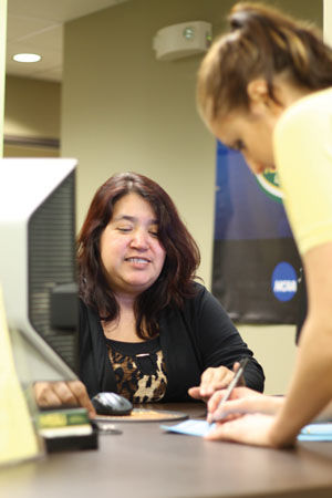 Financial Aid Secretary Mayra Gonzalez assists students with filling out FAFSA paperwork for the upcoming school year. The financial aid office is located on the first floor of Hearnes Hall. Photo illustration, taken on Wednesday, Feb. 25.