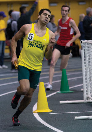 Junior sprinter Miles Migliara rounds the corner at the MSSU Lion Open in Leggett & Platt Athletic Center on Feb. 6, 2015. Migliara and the distance medley team placed fourth, bettering their seed time by three seconds.