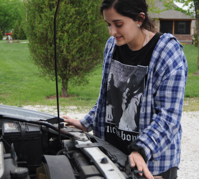 Mason Rickman checks her engine due to her car not starting on Monday, April 22. 