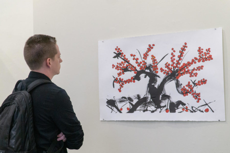 Grant Stebbins, sophomore graphic design major views Ashleys piece Persimmon Tree at the reception on Monday, Nov. 4, in the Spiva Art Gallery on Missouri Southern campus.